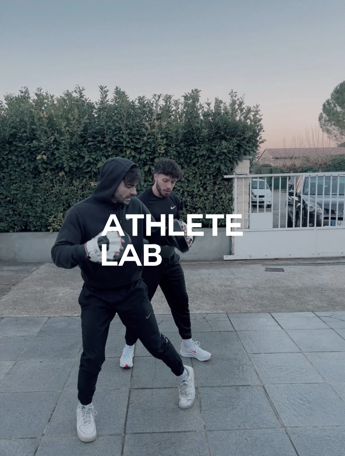 Un coach de boxe et un boxeur avec des gants.