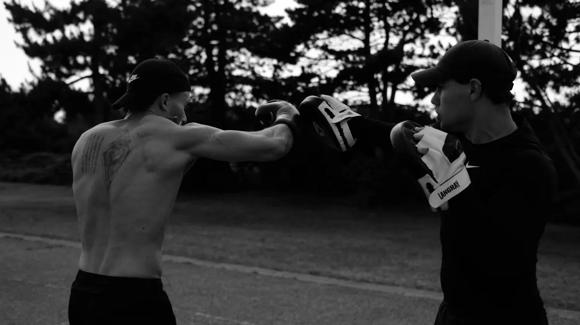 Un client et son coach sportif en train de réaliser un crochet du droit.