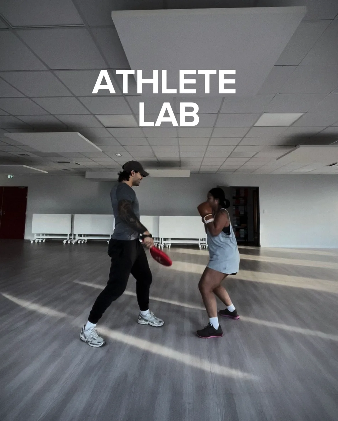 Un coach de boxe et une boxeuse avec des gants.